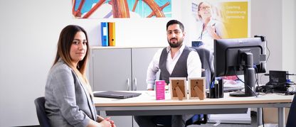 ingeus_Modul_2_Sprache_Ukrainian_Refugees_Integration_Support_Service_APM_16_9.jpg Junge Frau und ein Mann sitzen im Büro